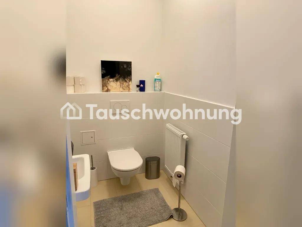 Separates WC mit wandhängender Toilette und Heizkörper.