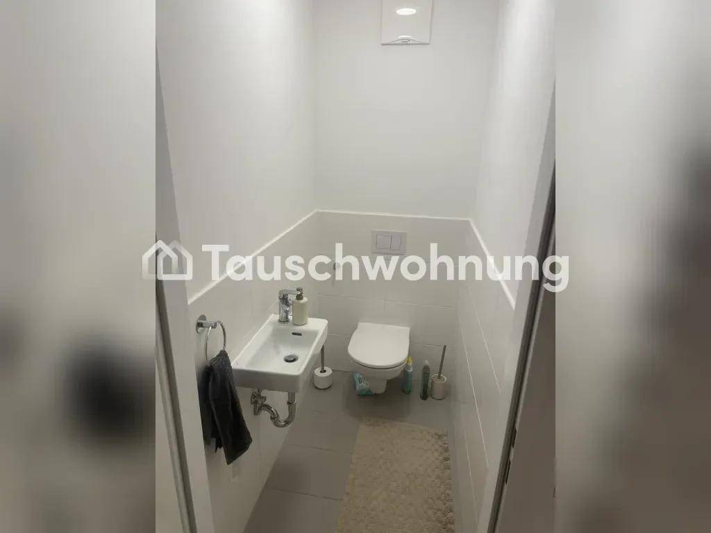 Modernes Gäste-WC mit wandhängendem WC, kleinem Waschbecken und weißen Fliesen.