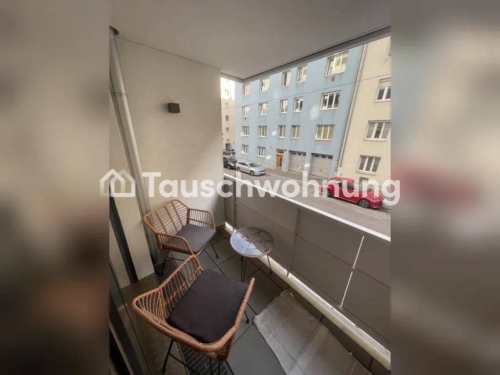 Gemütlicher Balkon mit Korbsesseln und Blick auf die umliegende Stadtstraße.