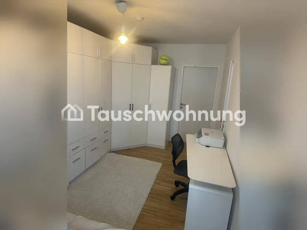 Geräumiges Schlafzimmer mit umfangreichen weißen Einbauschränken und einem Arbeitsbereich.