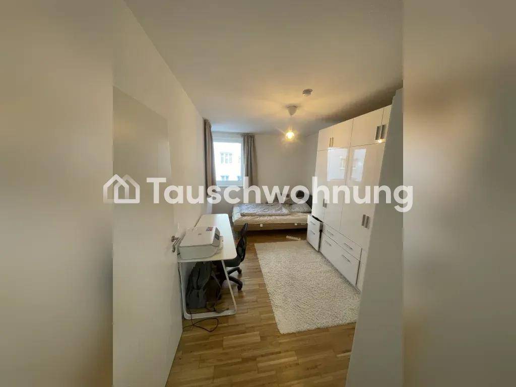 Schlafzimmer mit Bett, Schreibtisch und großem weißen Kleiderschrank, ausgestattet mit Holzboden.