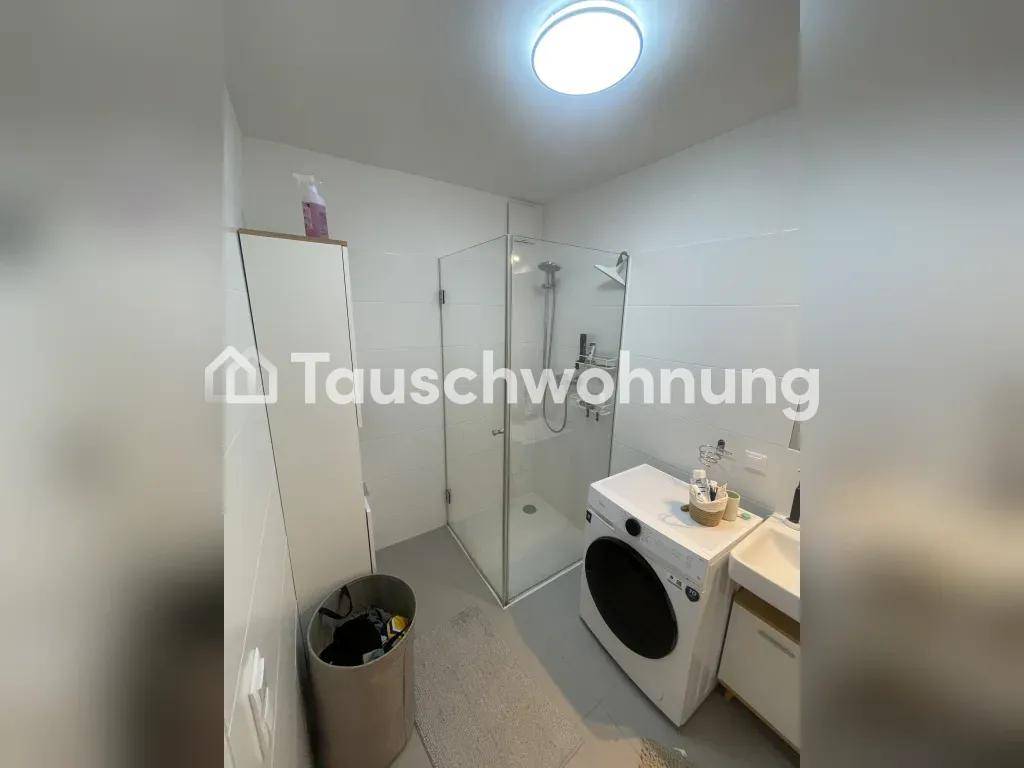 Modernes Badezimmer mit Glasdusche, Waschmaschine und Waschbecken mit Unterschrank.