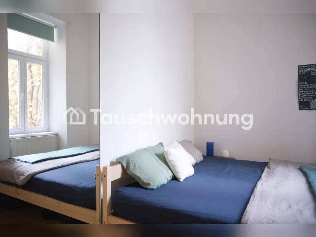 Schlafzimmer mit zwei Betten, einem Fenster und hellen Wänden.