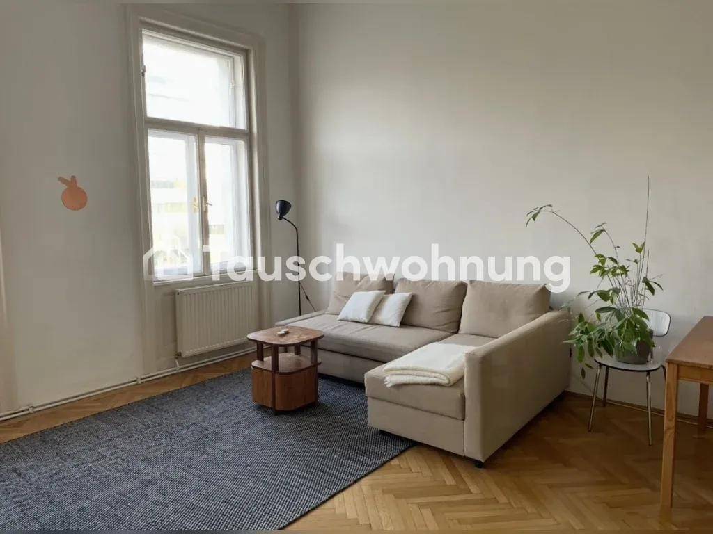 Gemütliches Wohnzimmer mit Ecksofa, Teppich und Fischgrätparkettboden.