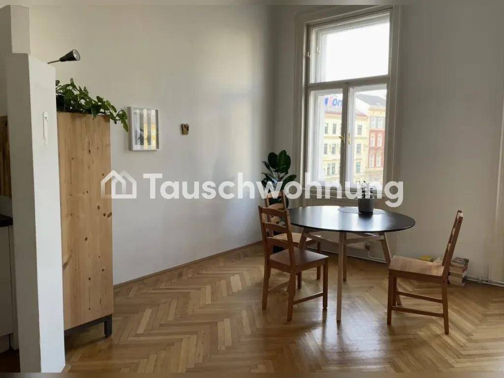 Essbereich mit dunklem Tisch und Holzstühlen, angrenzend an einen weiteren Raum.