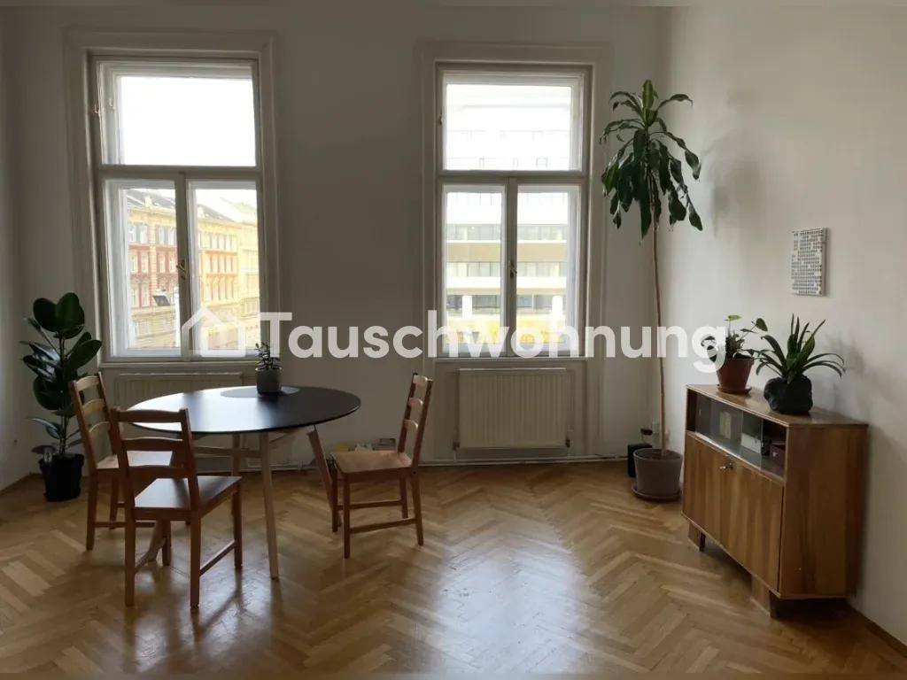 Essbereich mit rundem Tisch, Holzstühlen und Fischgrätparkettboden.