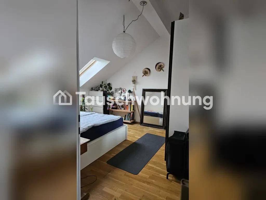 Gemütliches Schlafzimmer im Dachgeschoss mit Bett, Spiegel und Dachfenster.
