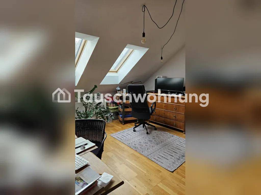 Helles Arbeitszimmer im Dachgeschoss mit zwei Dachfenstern und Holzboden.