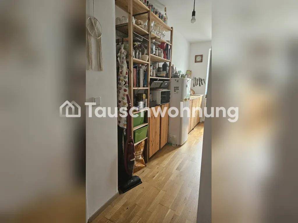 Küche mit Holzschränken, offenen Regalen und Holzboden.