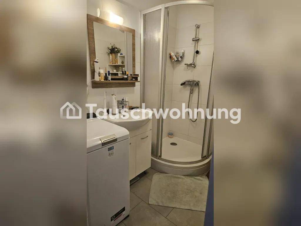 Badezimmer mit Waschbecken, Spiegel, Duschkabine und Waschmaschine.
