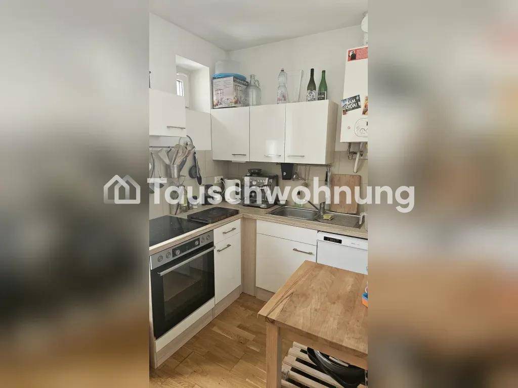 Moderne Küche mit weißen Schränken, Spüle und integriertem Geschirrspüler.
