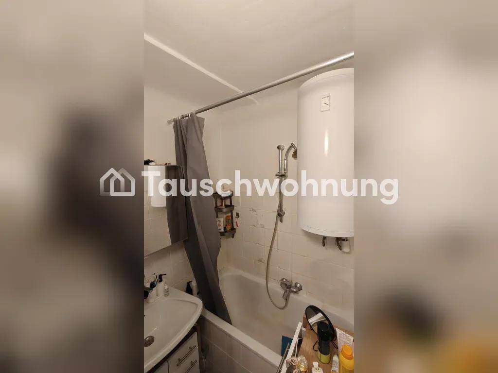 Badezimmer mit Badewanne, Waschbecken und einem Warmwasserboiler an der Wand.