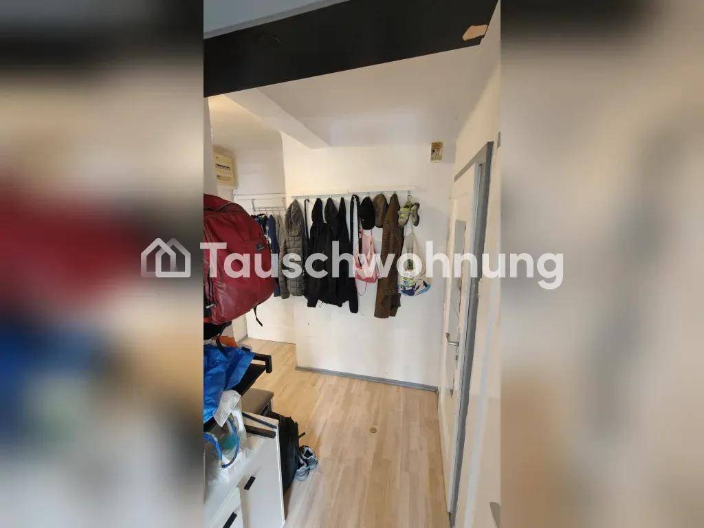 Eingangsbereich mit Garderobe und Treppe, die zu einem unteren Bereich führt, mit hellem Boden.