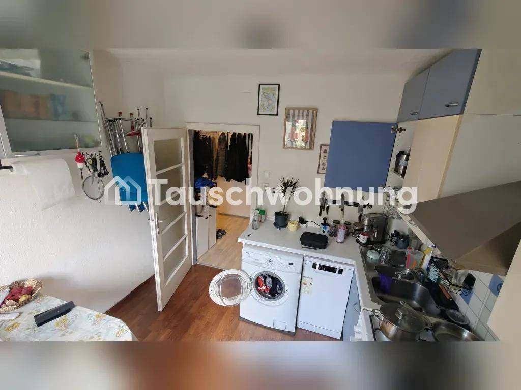 Küchenbereich mit integrierter Waschmaschine und Spülmaschine, angrenzend an den Flur.