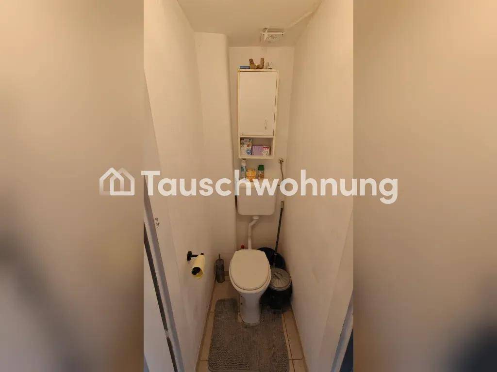 Kleines Gäste-WC mit Toilette und wandmontiertem Schrank in schlichtem Design.