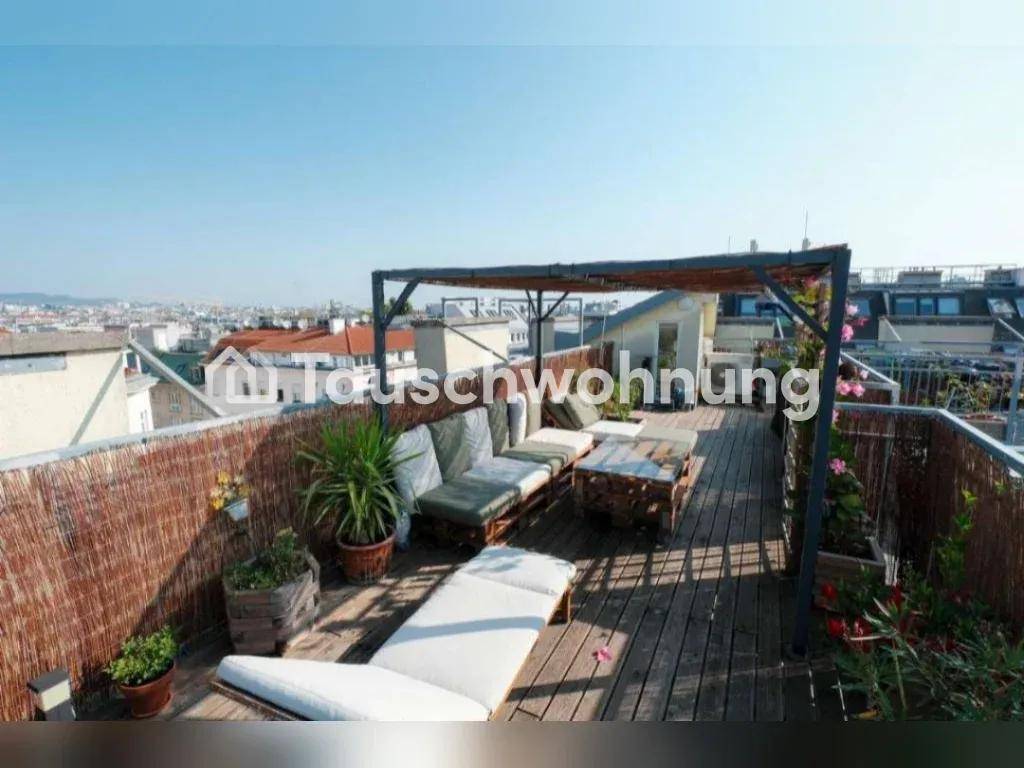 Weitläufige Dachterrasse mit Holzbelag, bequemen Sitzgelegenheiten und Panoramablick über die Stadt.