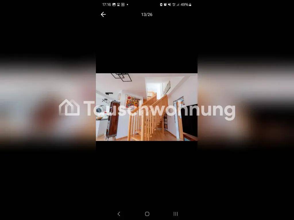 Heller Eingangsbereich mit einer eleganten Holztreppe, die in die obere Etage führt und viel natürliches Licht bietet.