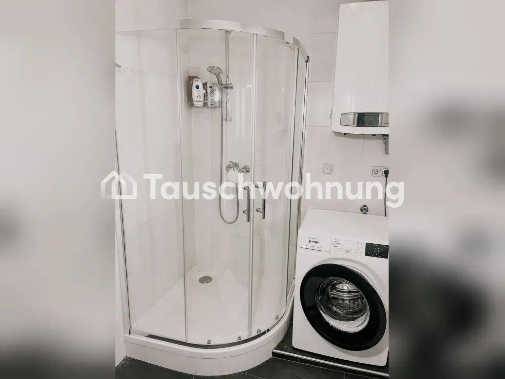 Detaillierte Ansicht der Duschkabine und Waschmaschine in einem modernen Badezimmer.