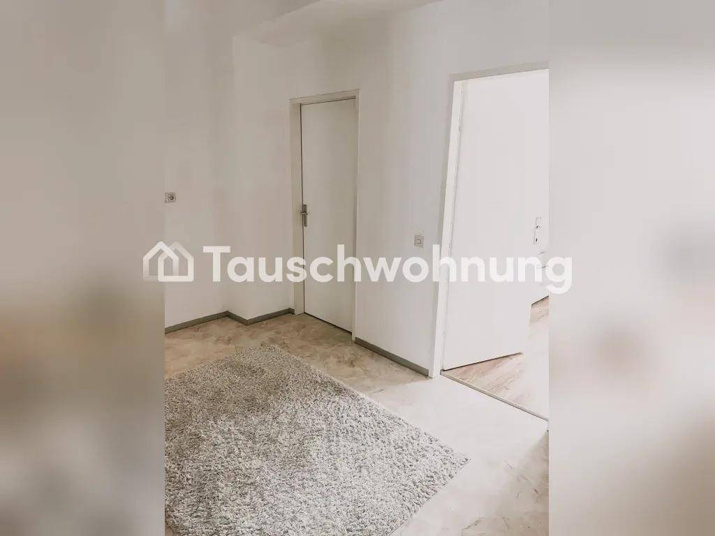 Heller Flur mit weiß gestrichenen Wänden, hellem Boden und einem weichen Teppich.