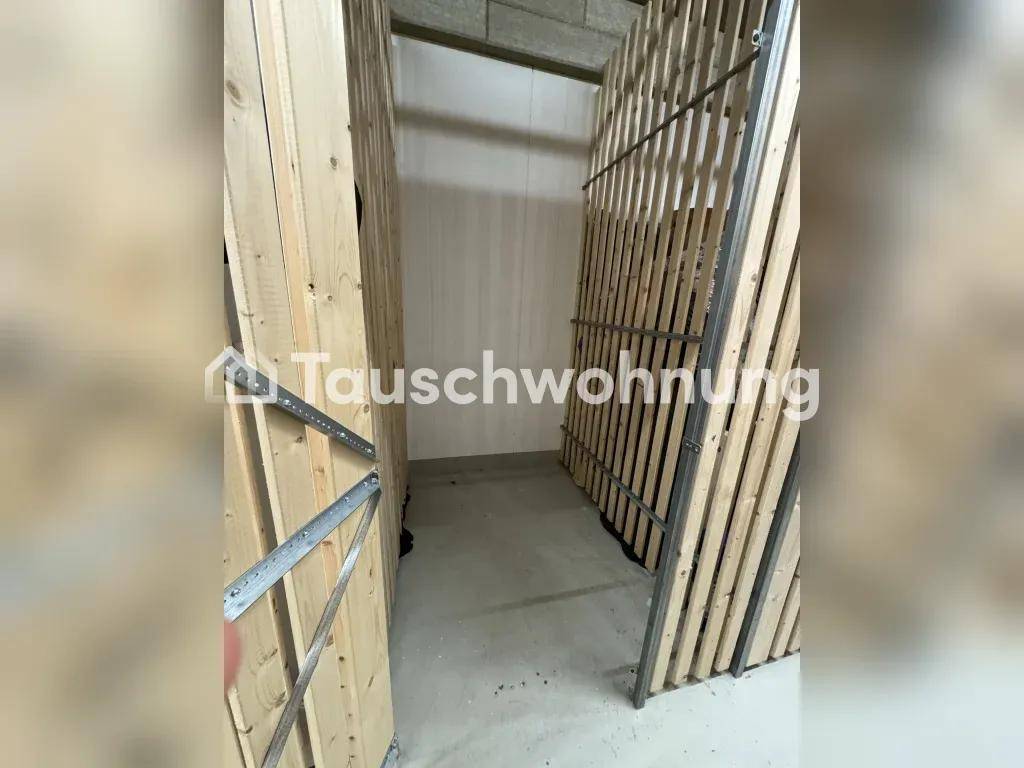 Praktischer Abstellraum mit Holzlattenwänden und Betonboden, ideal für zusätzlichen Stauraum.