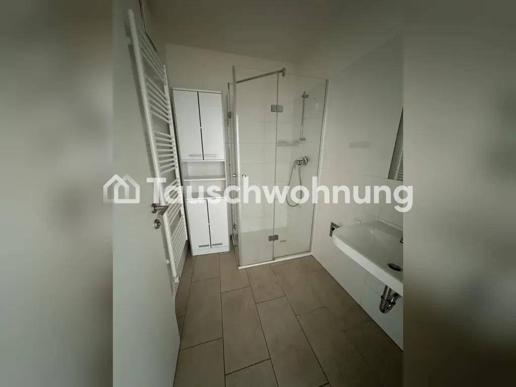 Modernes Badezimmer mit Duschkabine, Waschbecken, beheiztem Handtuchhalter und Stauraum, auf beigefarbenen Fliesen.
