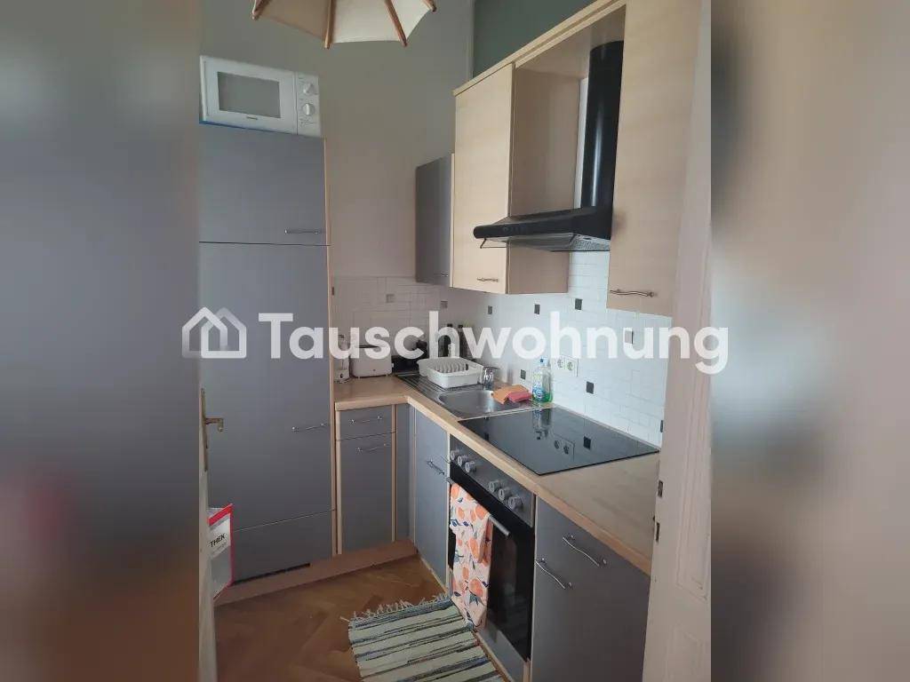 Kompakte Küche mit grauen Schränken, Induktionskochfeld und integrierten Geräten.
