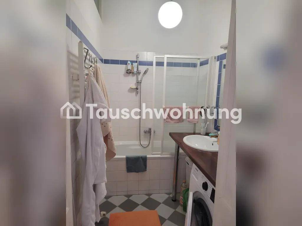 Badezimmer mit Badewanne, Duschabtrennung und Waschmaschine unter dem Waschtisch.