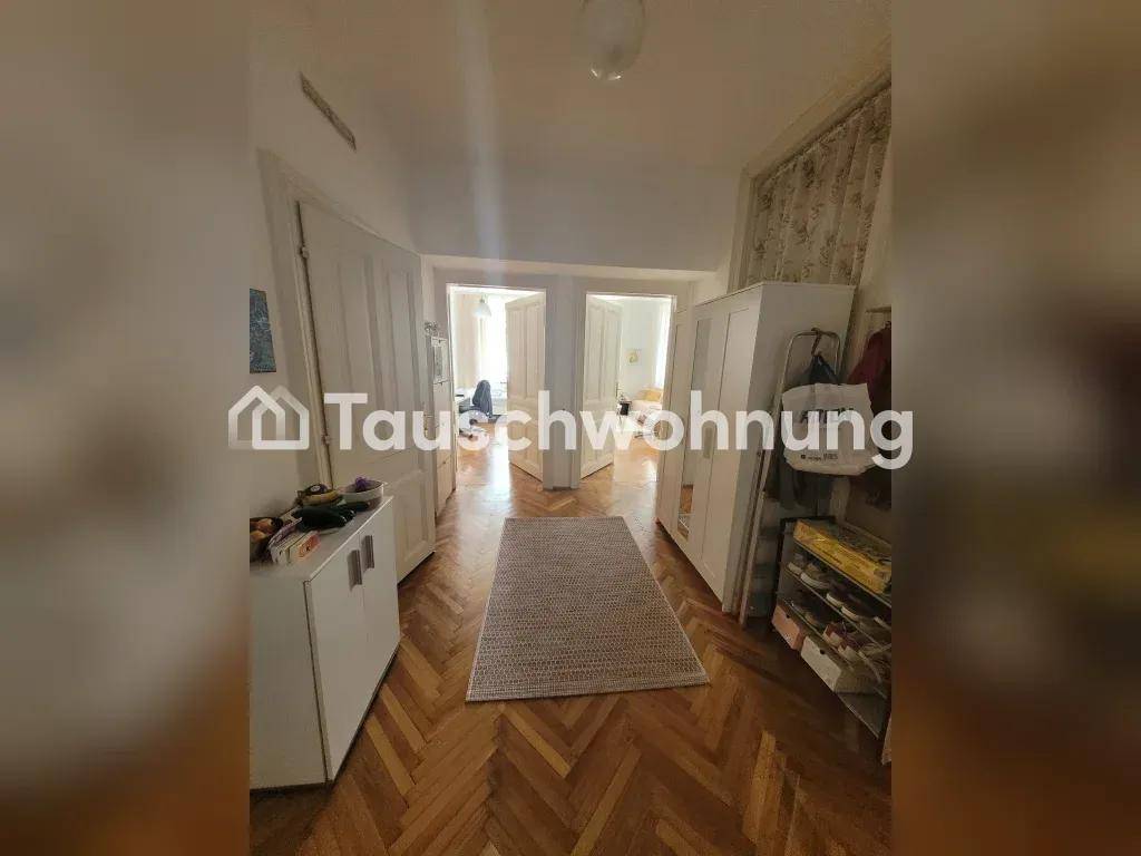Langer Flur mit Fischgrätparkett und mehreren Türen, die zu den angrenzenden Zimmern führen.