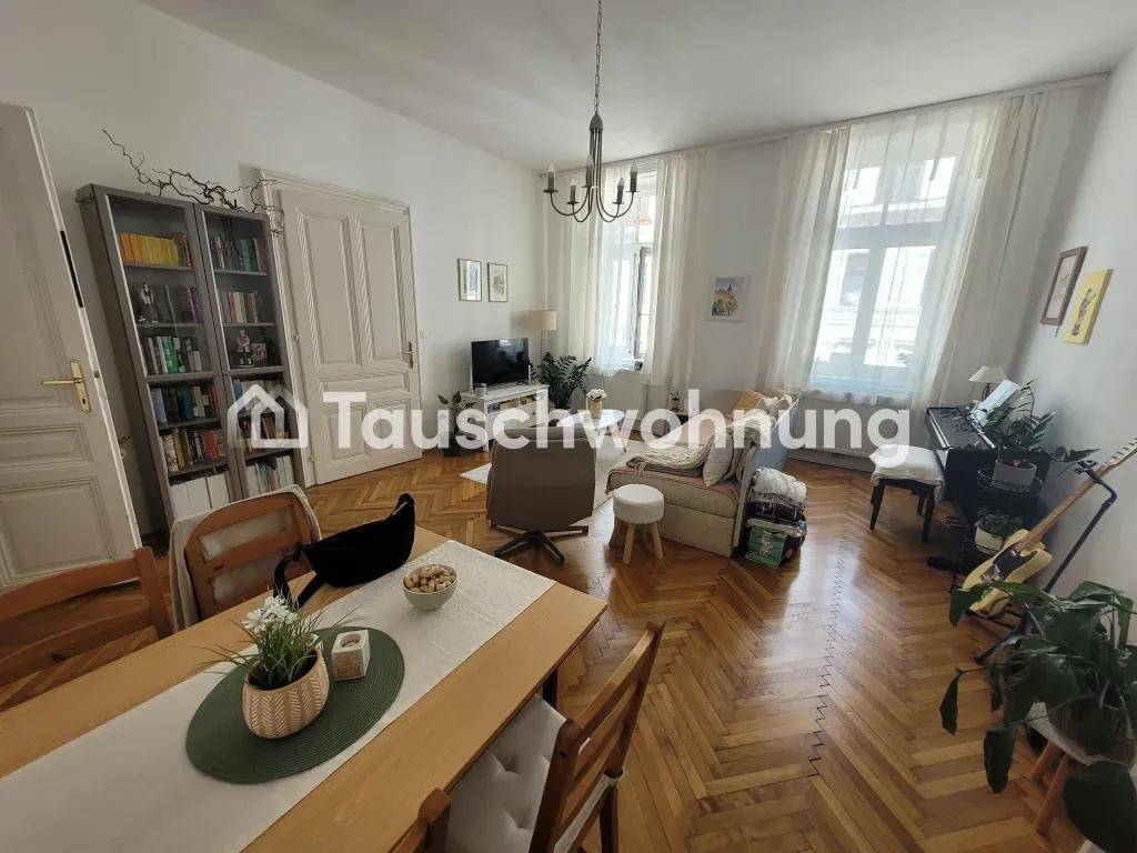 Geräumiger Wohn-Essbereich mit Holztisch, Bücherregal und Blick auf den Wohnbereich.
