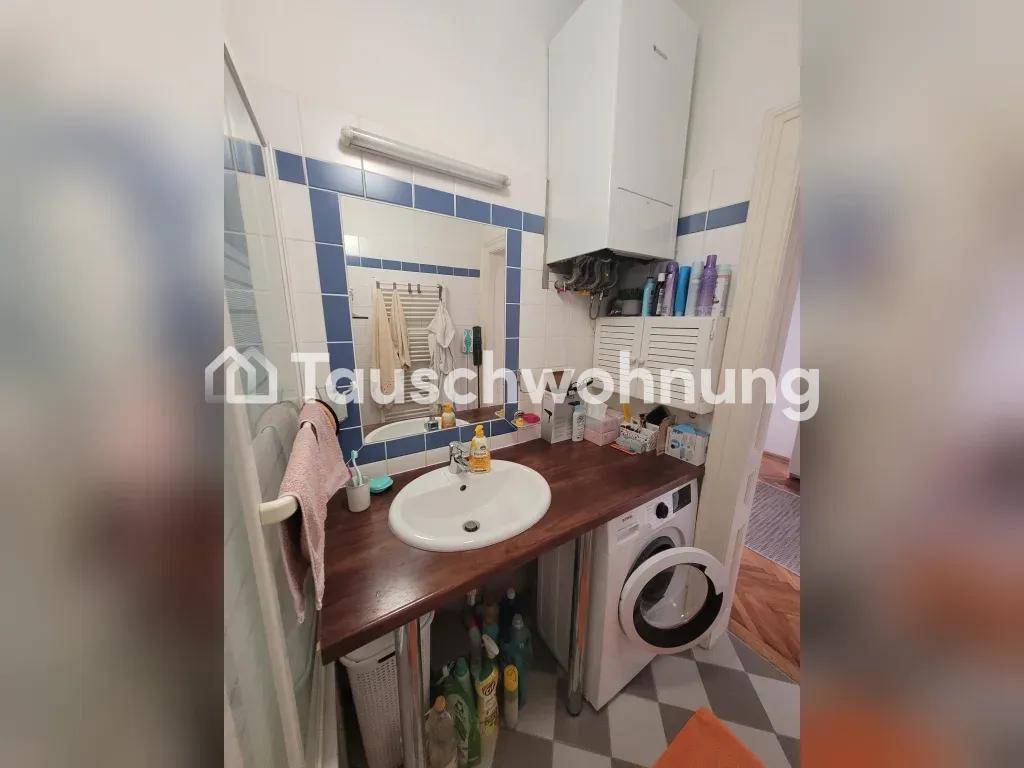 Badezimmer mit Waschbecken, großem Spiegel und Gastherme über dem Waschtischbereich.