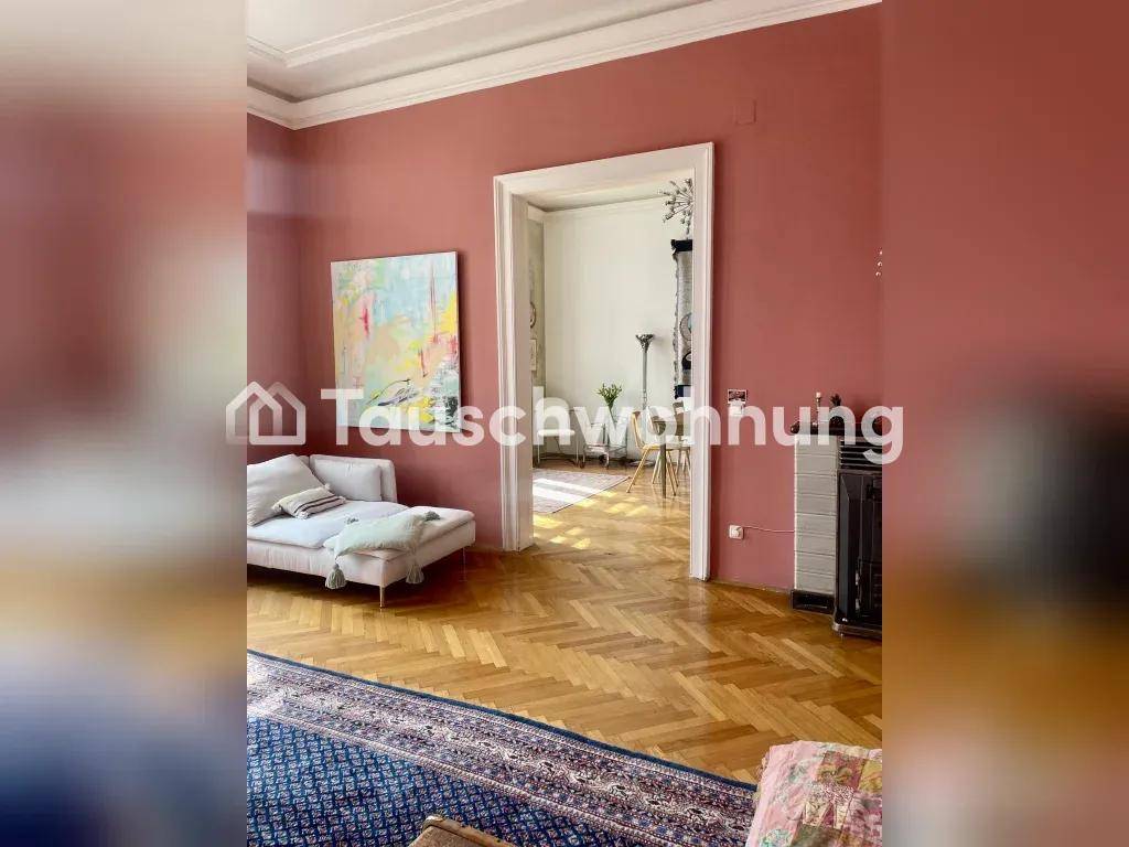 Geräumiges Wohnzimmer mit Fischgrätparkett und offenem Durchgang zu einem weiteren Raum.