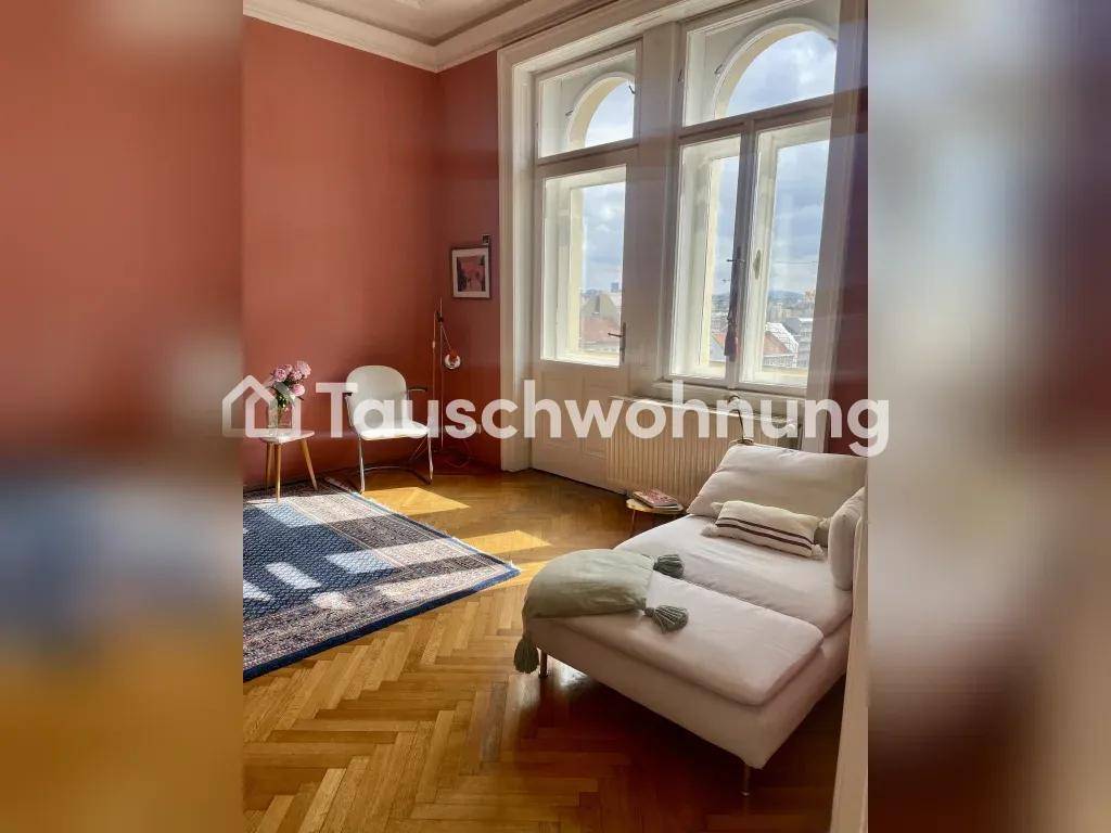 Gemütliches Wohnzimmer mit großen Bogenfenstern, Chaiselongue und Fischgrätparkettboden.