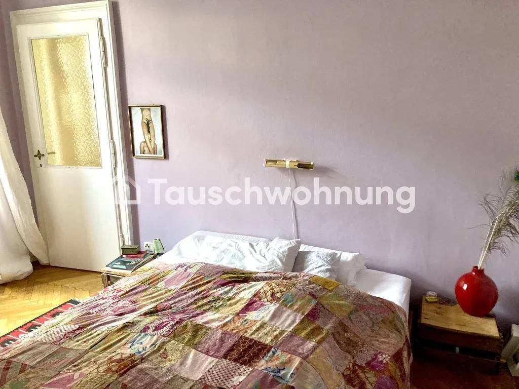 Schlafzimmer mit Bett, lila Wänden und klassischem Fischgrätparkettboden.