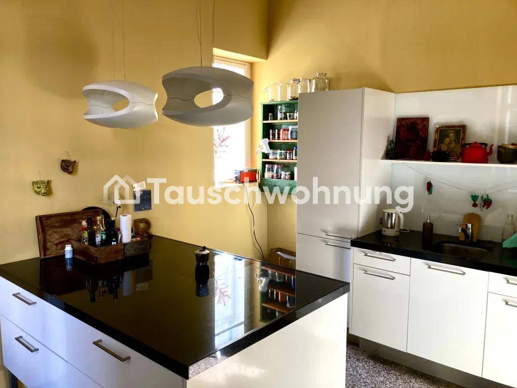 Moderne Küche mit weißen Schränken, schwarzer Arbeitsplatte und einer Kücheninsel.