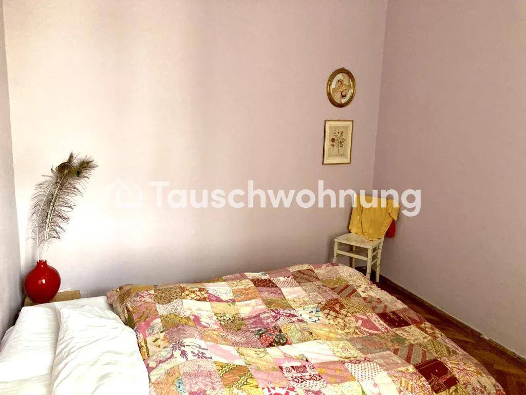 Gemütliches Schlafzimmer mit lila Wänden, Fischgrätparkett und einfacher Einrichtung.