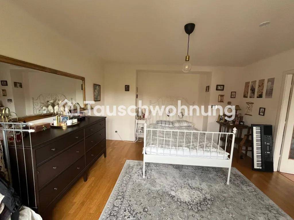Geräumiges Schlafzimmer mit Holzboden, einem großen Spiegel und einem einfachen Doppelbett.