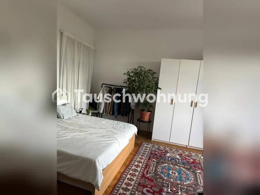 Schlafzimmer mit Doppelbett, weißem Kleiderschrank und Teppich auf klassischem Parkettboden.