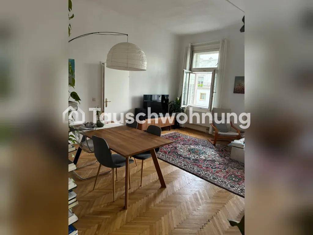Offener Wohn-Essbereich mit Holztisch, modernen Stühlen und Fischgrätparkettboden in hellem Ambiente.