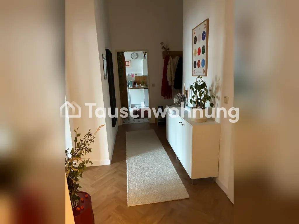 Heller Flur mit weißem Schrank, Teppichläufer und Zugang zu weiteren Räumen der Wohnung.