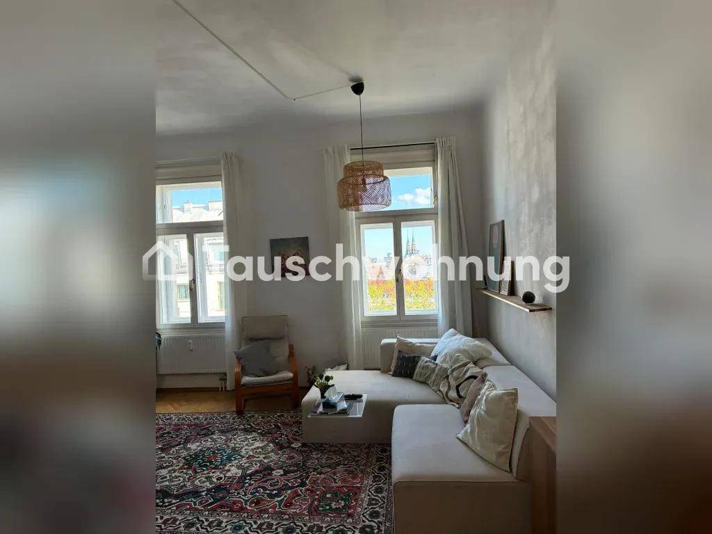 Helles Wohnzimmer mit gemütlichem Sofa, Teppich und zwei großen Fenstern, die viel Licht hereinlassen.