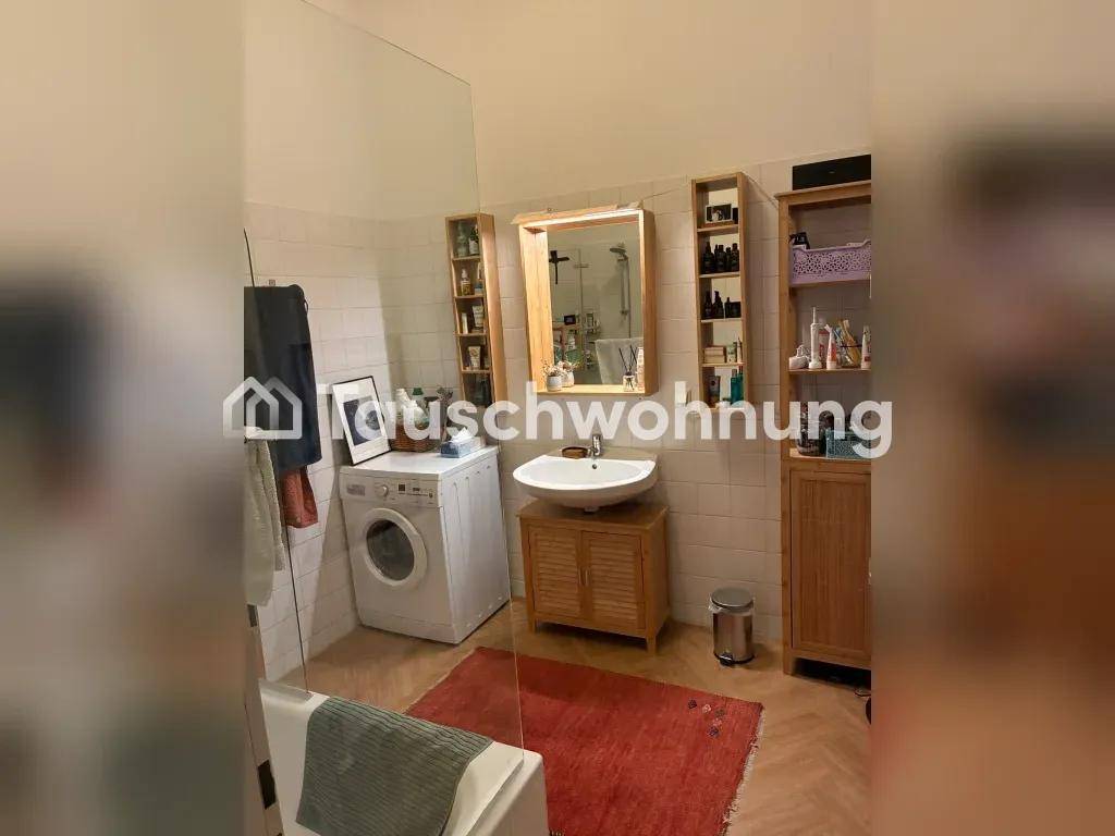 Badezimmer mit Waschbecken, Spiegelschrank, Waschmaschine und Badewanne, praktisch eingerichtet.