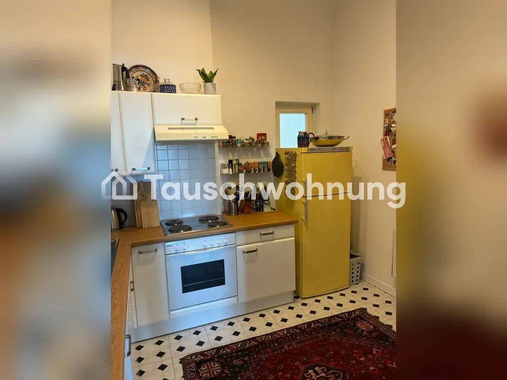Funktionale Küche mit Herd, Backofen und einem auffälligen gelben Kühlschrank, gut ausgestattet.