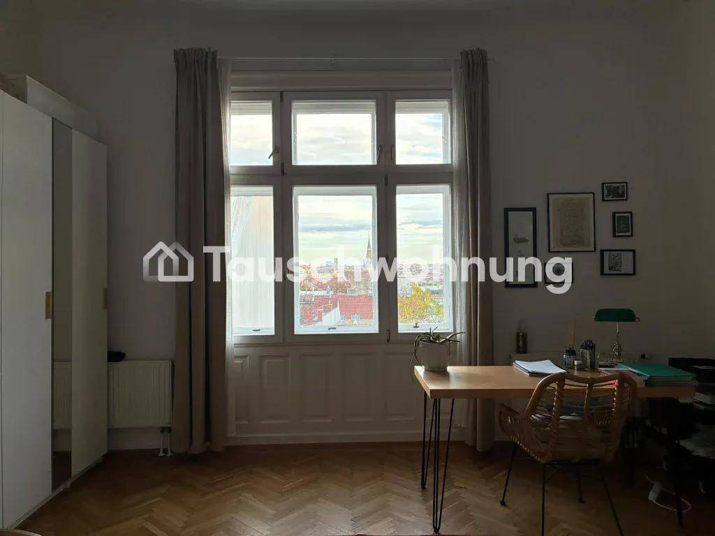 Arbeitszimmer mit großem Fenster, Schreibtisch und Stuhl, bietet einen weiten Blick über die Stadt.