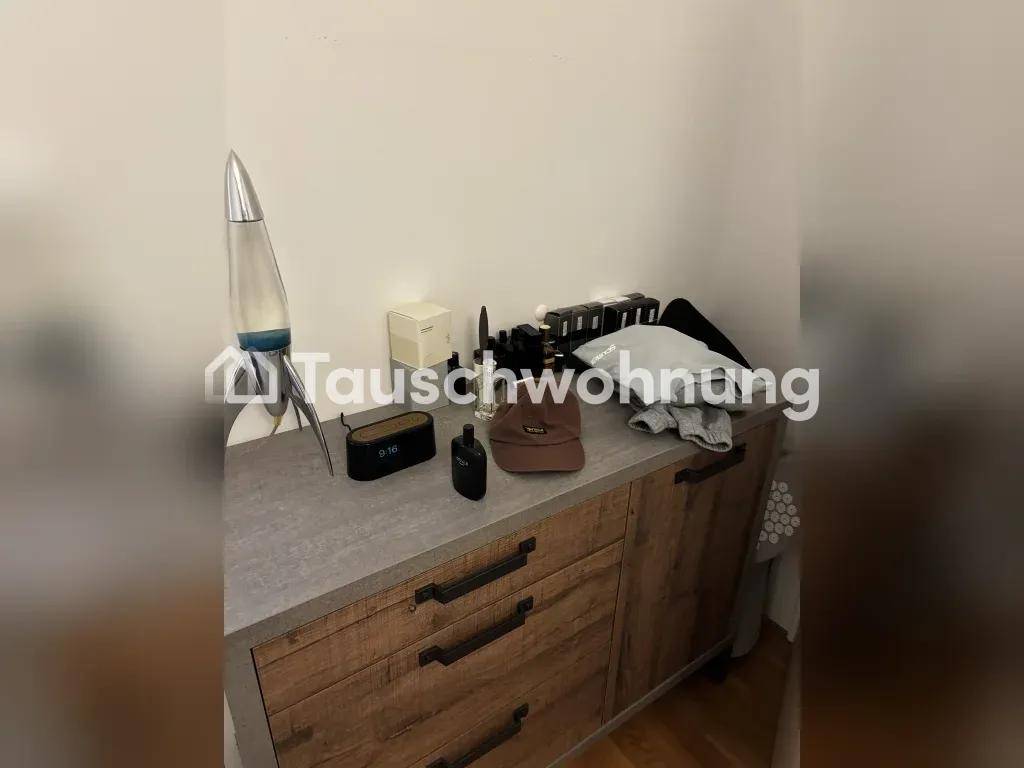 Holzkommode mit verschiedenen Gegenständen, darunter eine Lavalampe, in einem Wohnraum.