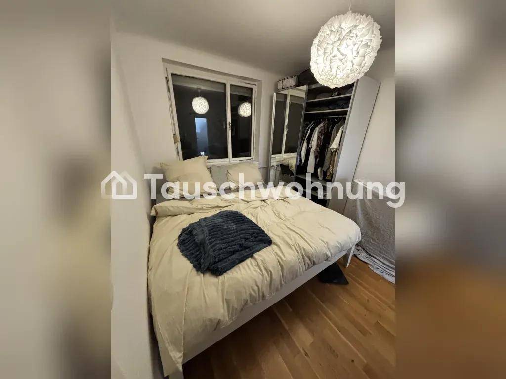 Schlafzimmer mit Bett, Fenster und einem Kleiderschrank mit Spiegeltür auf Holzboden.