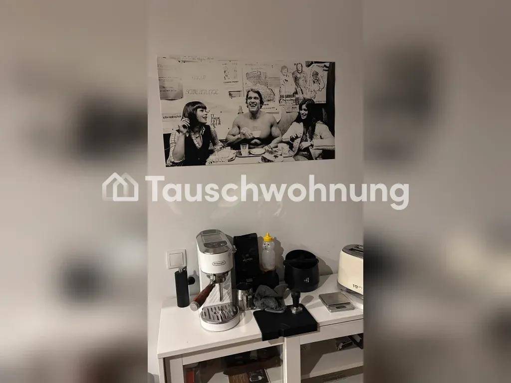 Arbeitsplatte mit Kaffeemaschine und Küchengeräten unter einem Schwarz-Weiß-Poster an der Wand.
