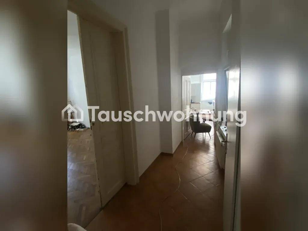 Langer Flur mit Fliesenboden, der verschiedene Räume der Wohnung miteinander verbindet.