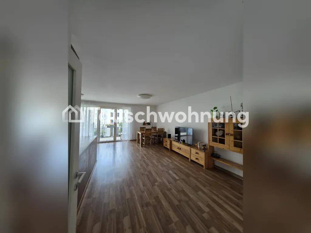 Geräumiger Wohn-Essbereich mit Laminatboden, Holzmöbeln und Zugang zum Balkon.
