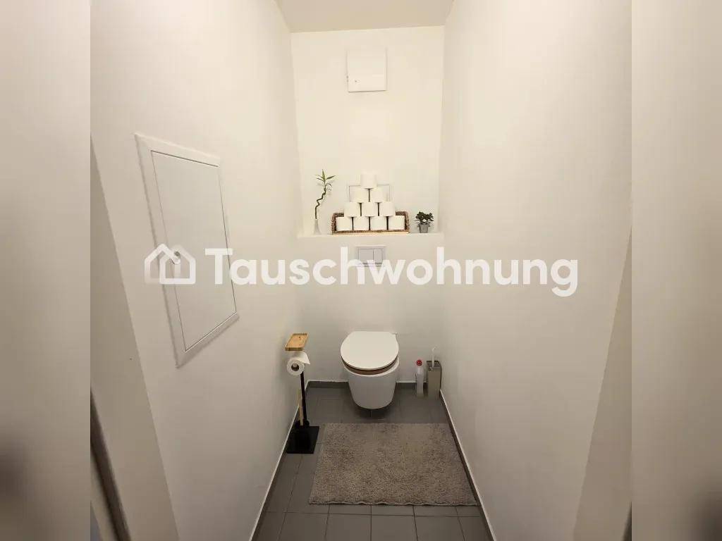 Kleines separates WC mit Wandtoilette und Fliesenboden.