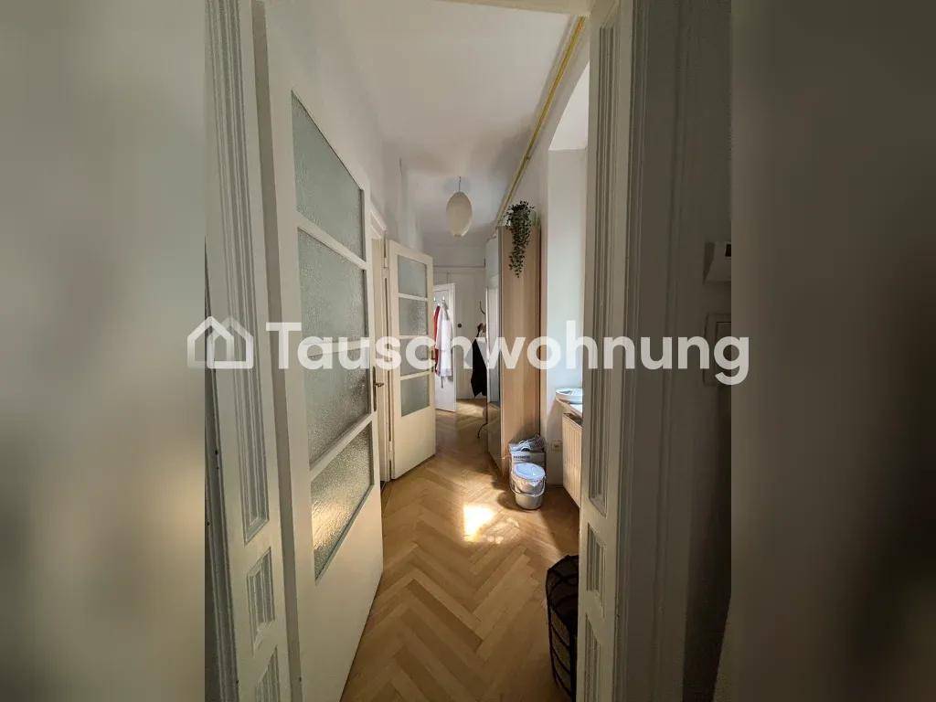 Heller Flur innerhalb der Wohnung mit Fischgrätparkett und Türen mit Glaseinsätzen, die zu weiteren Räumen führen.